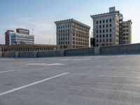 several large empty parking spaces in the city with buildings nearby in front of them -