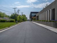 a building with a logo painted on the side near a street that has a sidewalk next to it