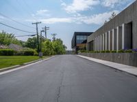 a building with a logo painted on the side near a street that has a sidewalk next to it