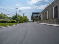 a building with a logo painted on the side near a street that has a sidewalk next to it