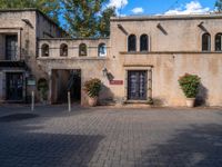 a large beige building with an open entry way leading to a restaurant and restaurant entrance