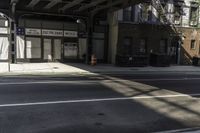 a street corner with a car parked under a bridge as if to get under the tracks