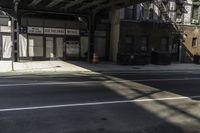 a street corner with a car parked under a bridge as if to get under the tracks