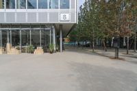 an empty courtyard in front of a building with a number 8 sign on it and wooden crates on the sidewalk