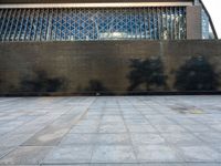 a concrete courtyard, with some people and buildings in the background at the same time