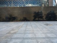 a concrete courtyard, with some people and buildings in the background at the same time