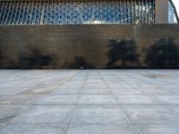 a concrete courtyard, with some people and buildings in the background at the same time