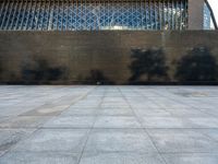 a concrete courtyard, with some people and buildings in the background at the same time