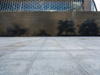 a concrete courtyard, with some people and buildings in the background at the same time