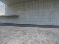 a red fire hydrant sitting on top of a stone floor in front of a white building