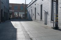 a skateboard is parked at the side of a building's entrance, while people ride on the sidewalk nearby