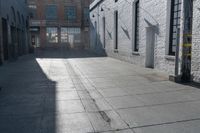 a skateboard is parked at the side of a building's entrance, while people ride on the sidewalk nearby