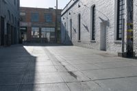 a skateboard is parked at the side of a building's entrance, while people ride on the sidewalk nearby