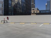 the empty parking lot has a lot of traffic cones near it to the side of the street