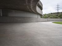 a building with cement roof near green grass and lawn in front of it, under a gray sky