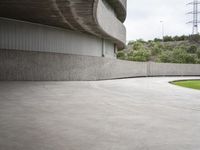 a building with cement roof near green grass and lawn in front of it, under a gray sky