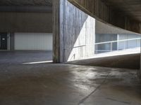 a skateboard in the middle of an empty building with some concrete walls and railing