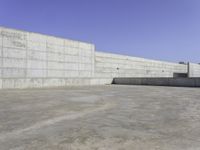 large concrete wall in a courtyard of a building with concrete walls and windows on the side of the wall