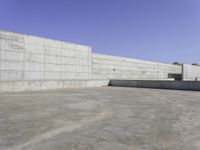 large concrete wall in a courtyard of a building with concrete walls and windows on the side of the wall