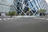 a view of a building with glass in it and traffic signs in the foreground