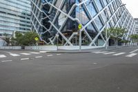 a view of a building with glass in it and traffic signs in the foreground