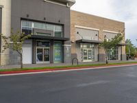 a gray street with store front and parking area on either side of road that has the name k - k's