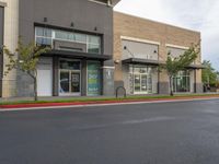 a gray street with store front and parking area on either side of road that has the name k - k's