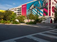 the view of a building with zebras and pink trees on the side of it