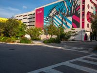 the view of a building with zebras and pink trees on the side of it