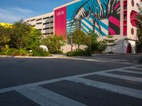 the view of a building with zebras and pink trees on the side of it