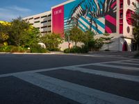 the view of a building with zebras and pink trees on the side of it