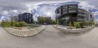 a 360 - angle image of buildings in a roundabout shape with trees and bushes and rocks