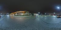 a full view of an empty parking lot at night time with a red fire hydrant and car parked on the side of it