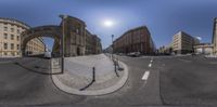 street intersection with circular mirrors reflecting buildings in it, with sun and a city street