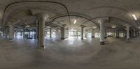 an empty, empty room with a big arched ceiling and concrete pillars, along with the entrance to another room