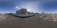 a big parking lot with many tall buildings in the background and another building below it