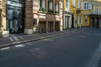 a number of building's in an alley with yellow walls and black doors and window sills