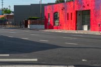 a man on a red motorcycle riding down the street on a crosswalk with buildings in the background