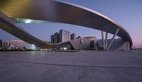 there is a large curved roof over a city street at night - like structure on top of an open area