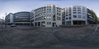 a fish eye lens is showing the building in the background and two buses parked near it