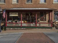 antique items displayed at the front porch of a store on a brick building with pillars