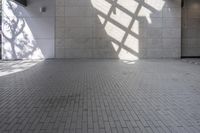 a brick floor that is on display in a room with large windows and floor tiles