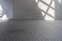 a brick floor that is on display in a room with large windows and floor tiles