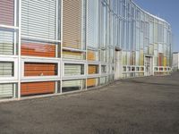 an area outside a building with colorful glass and a sign on the sidewalk indicating that the building is closed