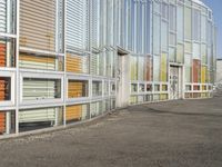 an area outside a building with colorful glass and a sign on the sidewalk indicating that the building is closed