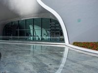 an empty modern building with a reflection in the pool water surrounding it's patio