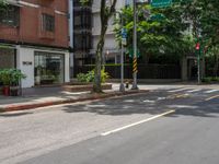 a street corner with no people walking on it and some trees on both sides of the street