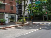 a street corner with no people walking on it and some trees on both sides of the street