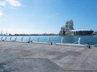 a view of the water with sea lion statue in background with clouds above and a body of water