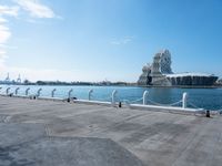 a view of the water with sea lion statue in background with clouds above and a body of water